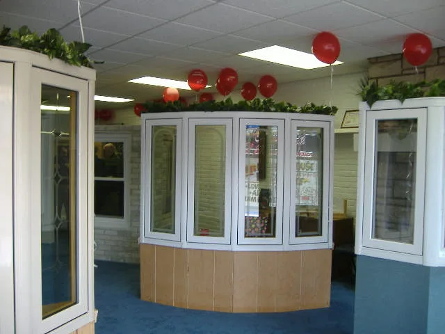 The Excel showroom decorated for an open house, bay and bow window displays under red balloons.