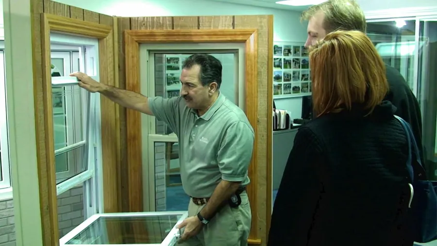 An Excel rep showing a tilt-in window to a couple in the Excel showroom.