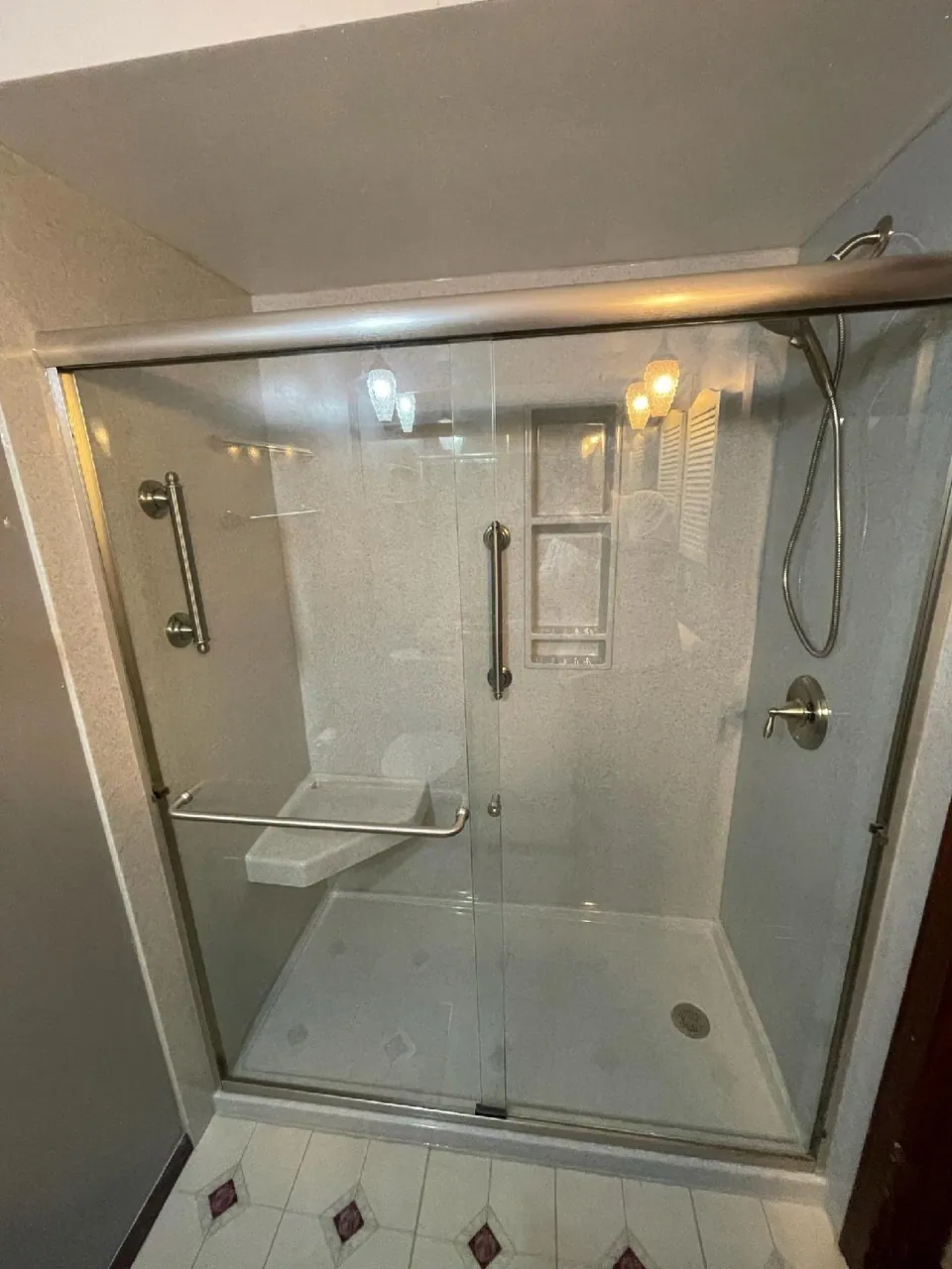 Accessible curbless walk-in shower with a fold-down bench, grab bars, and a handheld sprayer, Chicagoland