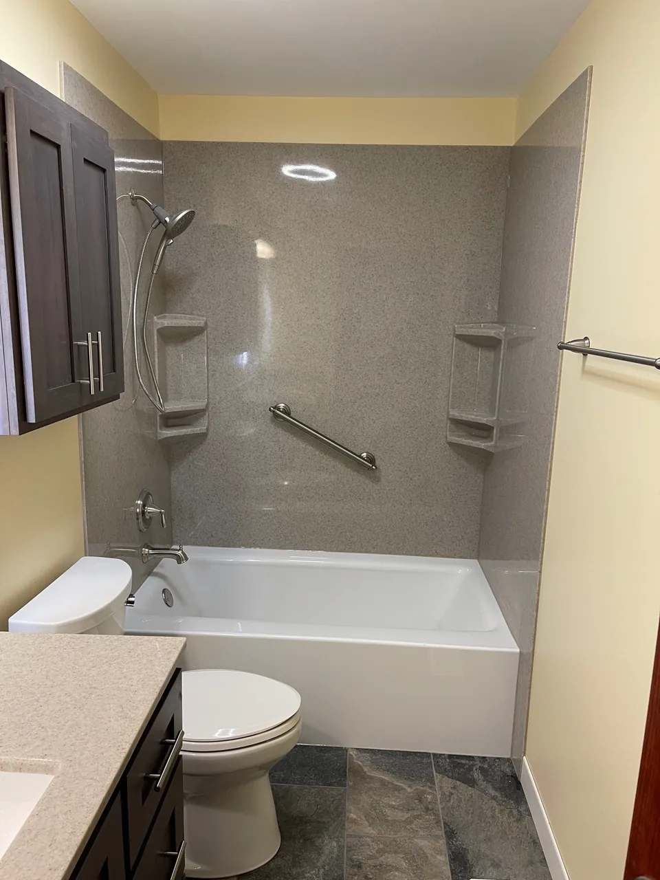 Replacement bathtub-and-shower with solid-surface surround, grab bars, and a built-in shelf niche, Chicagoland