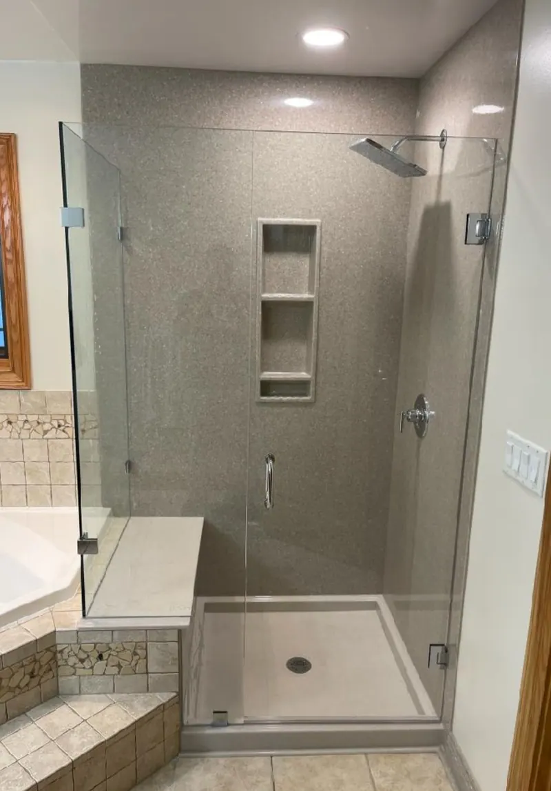 Finished Excel walk-in shower with solid-surface walls, a built-in niche, a corner seat, and a frameless-glass enclosure