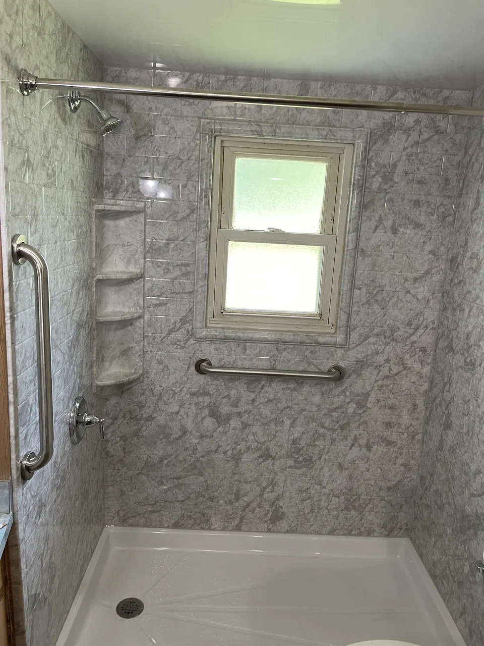 Walk-in shower with a grab bar and built-in shelf, an Excel install