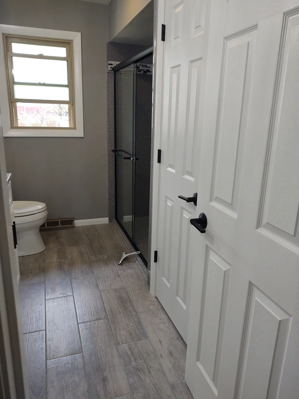 Gray wood-look plank tile flooring in a remodeled bathroom, Chicagoland