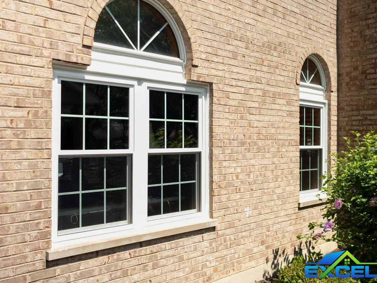 White double-hung windows with arched transoms in brick