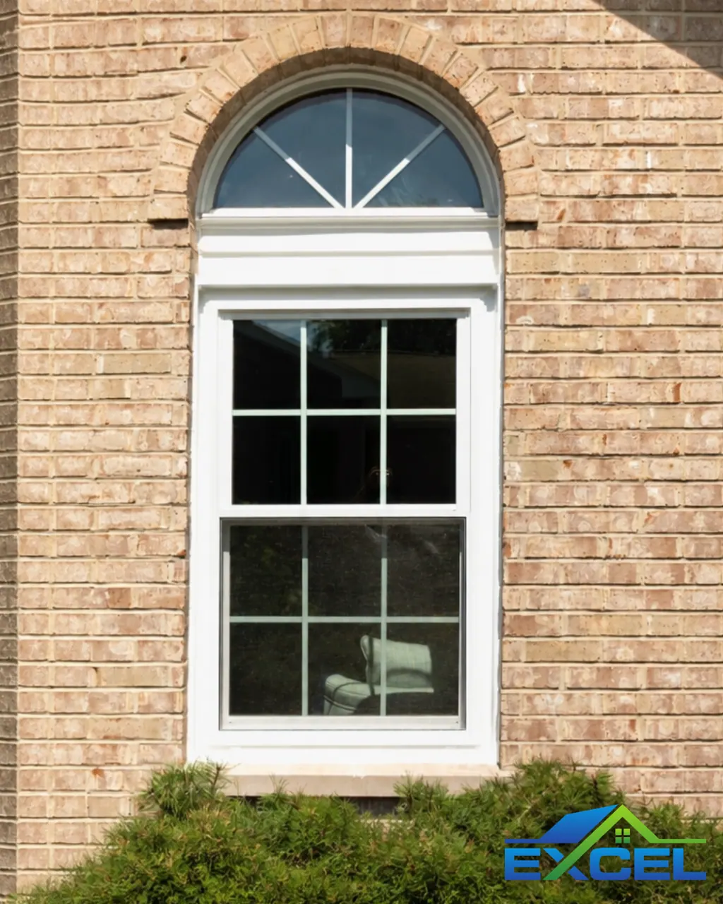 Tall arched double-hung window in a brick wall