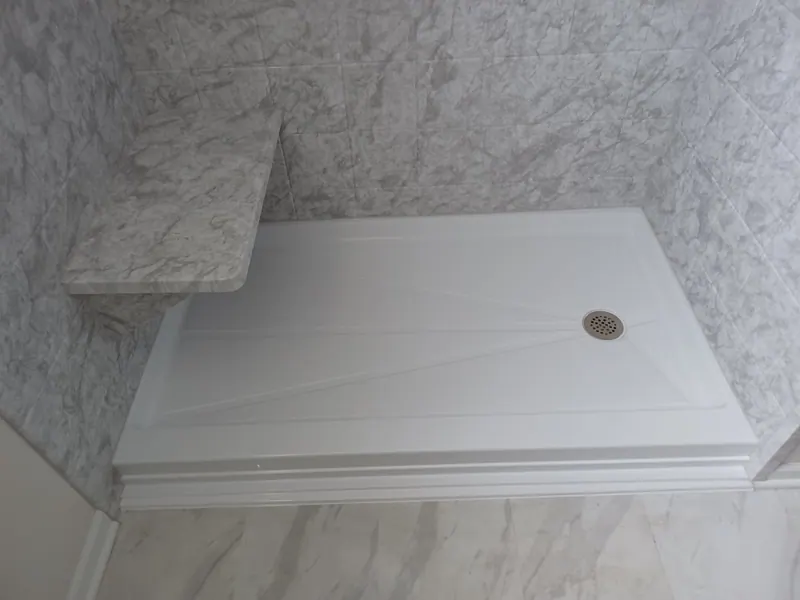 Finished walk-in shower with marble-look solid-surface walls and a built-in seat, an Excel install in the south suburbs